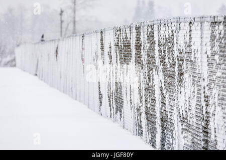 Maschendrahtzaun bedeckt mit Eis und Schnee, Thunder Bay, Ontario, Kanada. Stockfoto