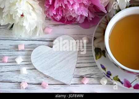 Päonien Blüten rosa Tasse Tee rattan Herzen Marshmallow auf weißem Hintergrund Holz-stock Bild Stockfoto