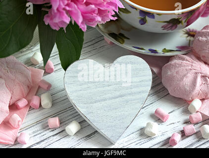Päonien Blüten rosa Tasse Tee rattan Herzen Marshmallow auf weißem Hintergrund Holz-stock Bild Stockfoto