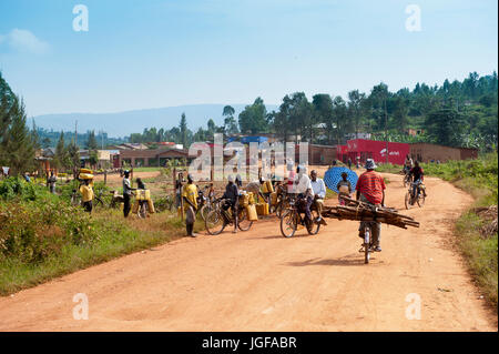 Belebten Straße am Eingang eines Dorfes in Ruanda, mit Menschen füllen Wasserkanister aus dem Fluss. Stockfoto