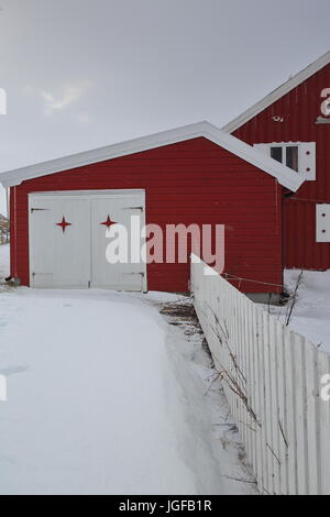 Weißer Zaun auf einem hölzernen Schuppen Gehäuse eine Garage, ein rot bemalten Häuschen mit weiß lackierten Tür befestigt. Nordmela-Andoy Kommune-Andøya Stockfoto