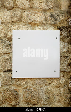 Weiße leere Schild am alten Steinmauer Stockfoto