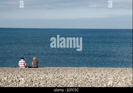 Paar sitzt am Strand von Bray in der Grafschaft Wicklow Stockfoto