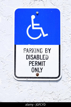 Behindertenparkplatz Zeichen auf Seite des Gebäudes Stockfoto