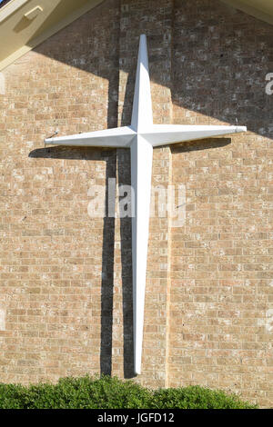 Ein Kreuz hängt an der Outsie Mauer der Kirche Stockfoto