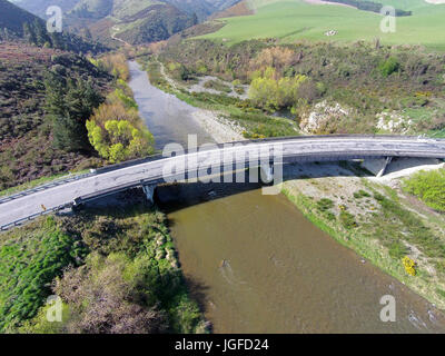 Gebogene Brücke über den Opuha River, zwischen Geraldine und Fairlie, South Canterbury, Südinsel, Neuseeland - Drohne Antenne Stockfoto