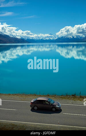 Auto auf der State Highway 8 und Aoraki / Mount Cook spiegelt sich in Lake Pukaki, Mackenzie Country, Canterbury, Südinsel, Neuseeland Stockfoto