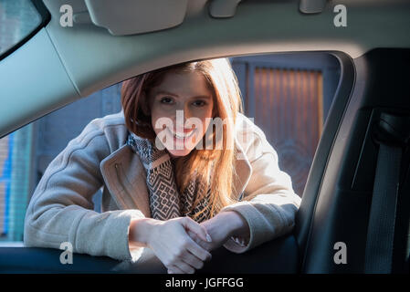 Kaukasische Frau stützte sich auf Autotür Stockfoto