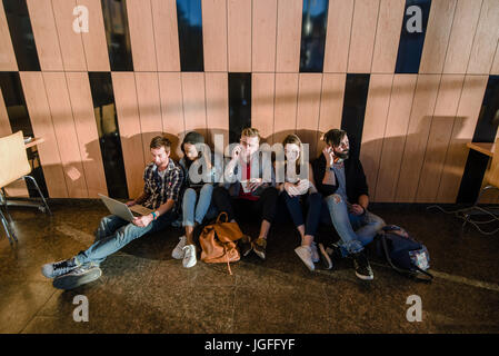 Gruppe von Studenten, die in den großen Raum entspannend. Studenten sitzen auf dem Boden. Stockfoto