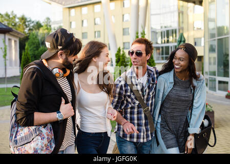 Lächelte, junge Menschen zu Fuß auf dem Campus und Gespräch. Jung und fröhlich Studenten. Stockfoto