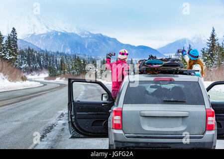 Kaukasischen Frauen fotografieren aus dem Auto mit snowboards Stockfoto