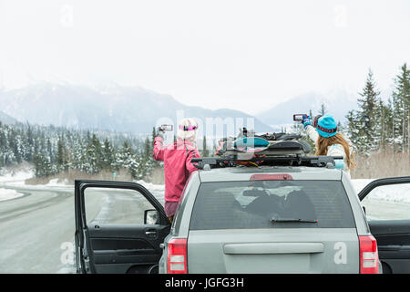 Kaukasischen Frauen stehen im Auto im Winter Panorama fotografieren Stockfoto