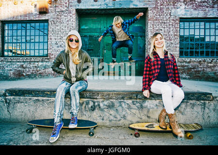 Freunde mit Skateboards lächelnd auf die Laderampe Stockfoto