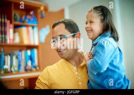 Hispanische Vater Holding-Tochter mit Down-Syndrom Stockfoto