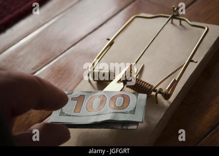 Hand des Hispanic Mann, indem Geld in Mausefalle Stockfoto