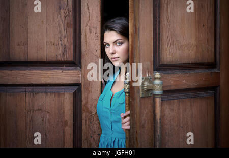 Kaukasische Frau Eröffnung Holztür Stockfoto