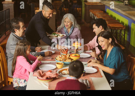 Kellner, Essen, Familie im Restaurant serviert Stockfoto