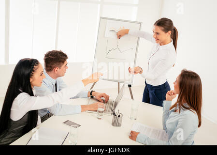 Geschäftsleute treffen in einem Büro. Junge Geschäftsfrau stand vor Flip-Chart und mit Präsentation. Stockfoto