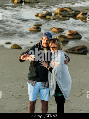 Paar posieren für ein Selfie am Strand. Stockfoto
