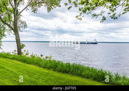 Frachtschiff am Sankt-Lorenz-Strom im Sommer mit ruhigem Wasser und grünen Rasen Stockfoto