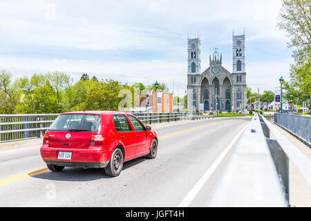 Sainte-Anne-de-la-Perade, Deutschland-29. Mai 2017: Pfarrkirche Sainte Anne De La Perade in Kleinstadt am Chemin du Roy mit Brücke und roten Auto unterwegs Stockfoto