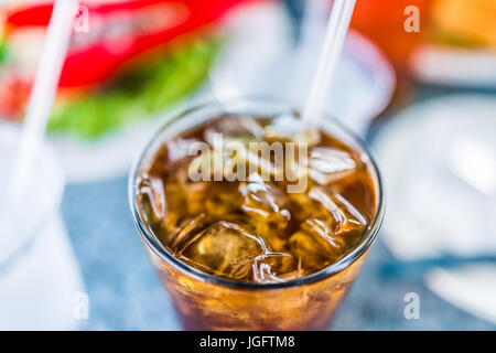 Makro Nahaufnahme Eistee oder Cola mit Eis und Strohhalm im Glas Stockfoto