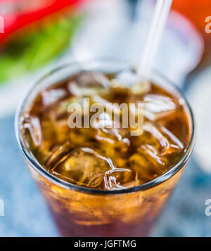 Makro Nahaufnahme Eistee oder Cola mit Eis und Strohhalm im Glas Stockfoto