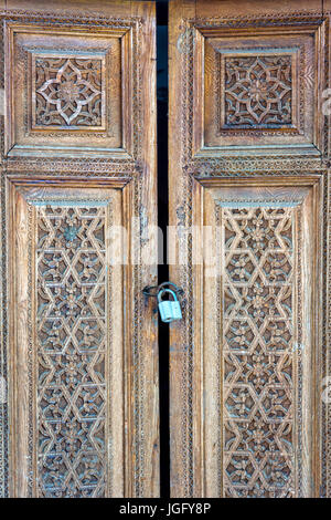 Alte geschnitzte Holztür mit dem Vorhängeschloss. Usbekistan Stockfoto