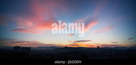 Wunderschönes Panorama natürliche Sonnenuntergang Sonnenaufgang über Silhouetten Skyline und erstaunliche orange Wolke blauer Himmel darüber. Stockfoto