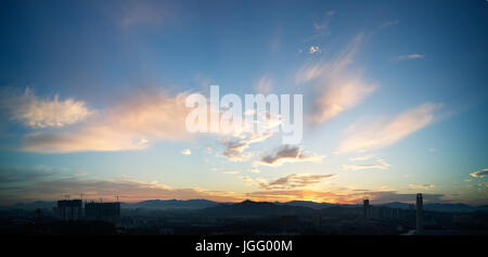 Wunderschönes Panorama natürliche Sonnenuntergang Sonnenaufgang über Silhouetten Skyline und erstaunlich gelbe Wolke blauer Himmel darüber. Stockfoto