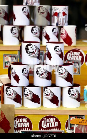 DOHA, Katar - 6. Juli 2017: Becher mit der Nationalflagge und eine Zeichnung der Qatari Emir Scheich Tamim bin Hamad al-Thani auf die Hauptstadt Souq Waqif Markt während der Krise zwischen Katar und arabischen Nachbarstaaten Stockfoto