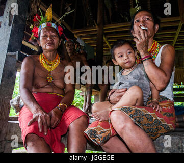 MENTAWAI Leute, WEST-SUMATRA, Indonesien Insel SIBERUT-03 OKTOBER 2011: Zwei Frauen des Mentawai-Stammes vor der Tür seines Hauses sitzen Stockfoto