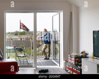 Porträt der Bewohner auf seinem Balkon mit britischer Flagge. Bruyn Gericht, South Ockendon, Vereinigtes Königreich. Architekt: Bell Phillips Architekten, 201 Stockfoto