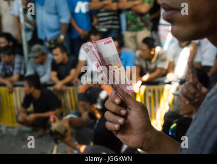 Männer, die das Geld für die Wetten während eines Cockfigting Ereignisses, Insel Bali, Canggu, Indonesien Stockfoto