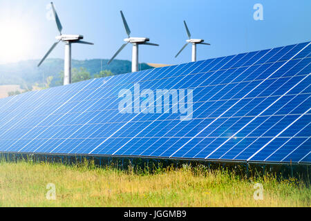 Zusammengesetztes Bild von erneuerbaren Energiequellen - Solarpark für Photovoltaik und Windmühlen für Windenergie Stockfoto