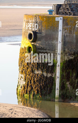 Hafenmauer und Eingang zum Hafen von Padstow mit Gezeiten Maßnahme am Hafen Wand Eingang mit Flut heraus an Sommertag Stockfoto