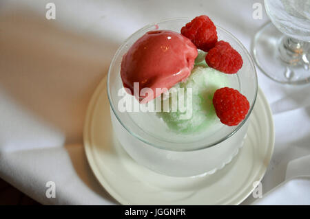 Leckere Sommer-Dessert frische Himbeere mit zwei Eissorten fruchtig serviert in einer Glasschale von oben gesehen Stockfoto