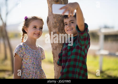 Glücklich Geschwister nehmen Selfie auf Handy im park Stockfoto