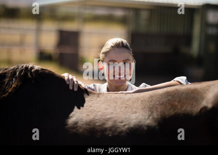 Porträt von lächelnden Frau mit einem braunen Pferd in der ranch Stockfoto