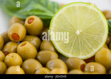 Nahaufnahme von grünen Oliven mit Zitrone und Kräutern Stockfoto