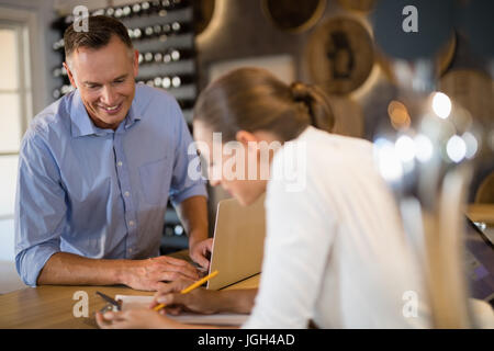 Lächelnd, Manager und Barkeeper diskutieren über Zwischenablage in der Bar Stockfoto