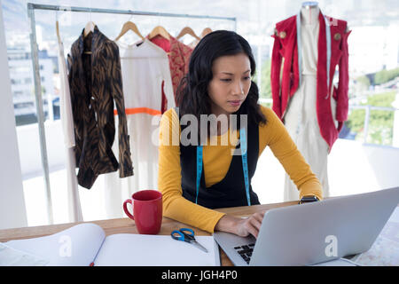 Designerin mit Laptop im Büro Stockfoto