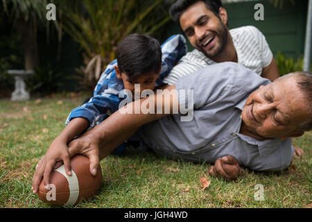 Glückliche Familie amerikanischer Fußball spielen auf Feld in Hof Stockfoto