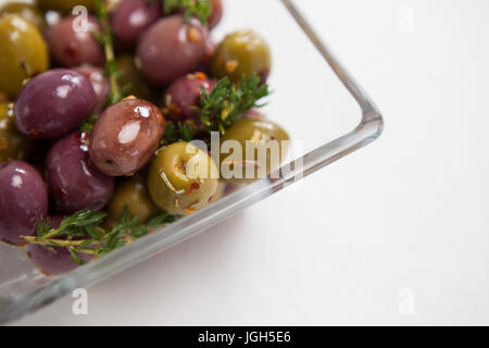 Bild von Oliven mit Thymian serviert in Glasschüssel auf Tabelle abgeschnitten Stockfoto