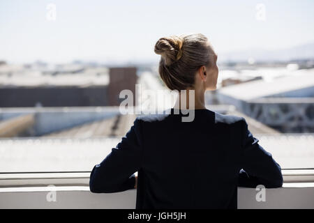 Rückansicht des nachdenklichen Geschäftsfrau Blick durch Fenster im Büro Stockfoto