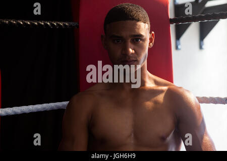 Porträt von zuversichtlich Mann sitzt im Boxring im Fitness-studio Stockfoto