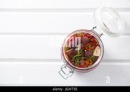 Eingelegte Oliven und Gemüse im Glas auf Holztisch Stockfoto