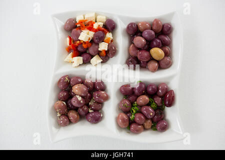 Marinierte Oliven mit Kräutern und Gewürzen auf weißem Hintergrund Stockfoto