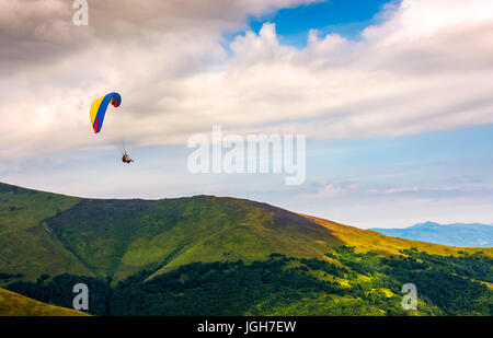 Fallschirmspringen in den Wolken über die Berge fliegen. Fallschirm-Extremsport Stockfoto