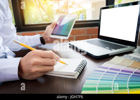 Händen der männliche Hipster modernen Grafik-Designer im Büro arbeiten mit Farbmustern. Mann am Arbeitsplatz Wahl Farbkarten, Nahaufnahme. Kreative Pers. Stockfoto
